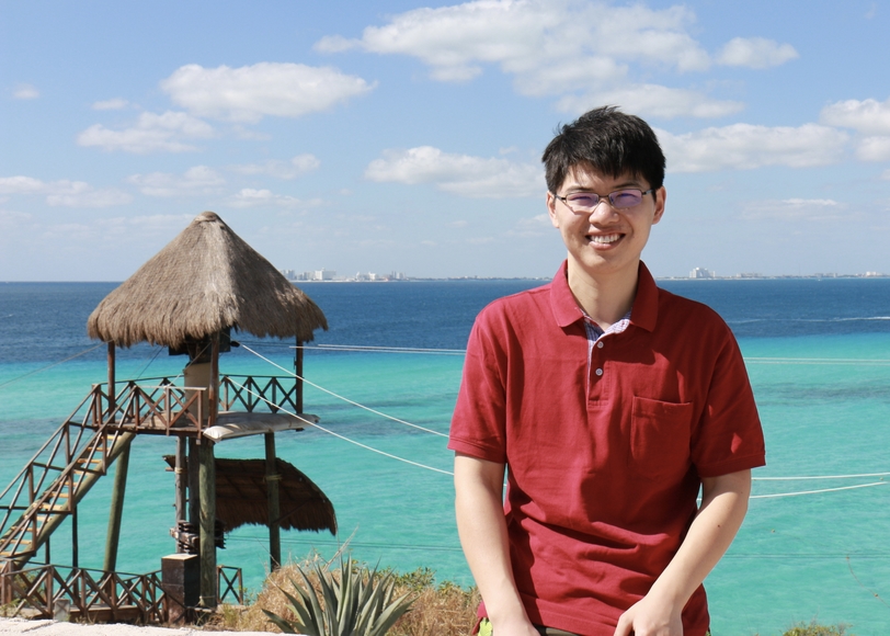 Portrait of Cong Ma pictured in front of a tropical ocean