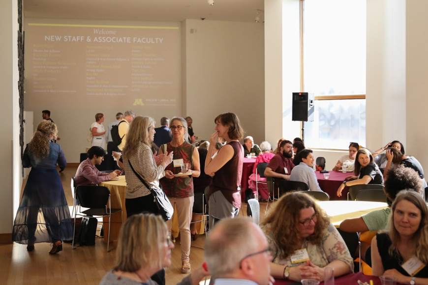 Members of the CLA community mingling at tables in the Weisman Art Museum