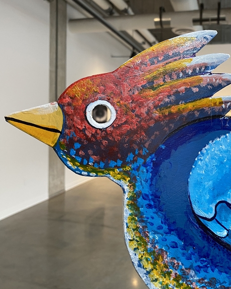 Brightly painted wooden bird in an art gallery