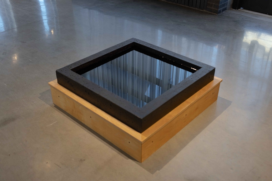A square black platform filled with water, reflecting the curtains of the Nash Gallery, by Hayden Teachout MFA 2022