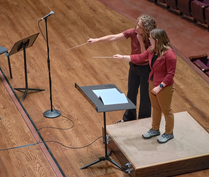 Dr. Emily Threinen works with a participant of the WInd Band Conducting Workshop