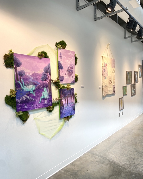 Purple assemblage artwork hanging on a white gallery wall