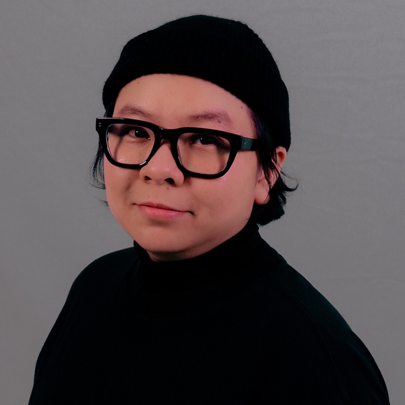 A Vietnamese woman in black cap, shirt, and glasses