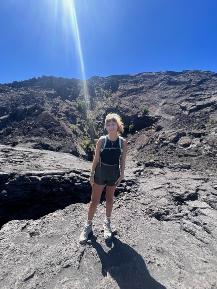 Olivia Berndy stands on rocky terrain.