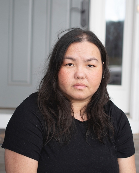 Photo of Pao Houa Her wearing a black t-shirt and looking into the camera