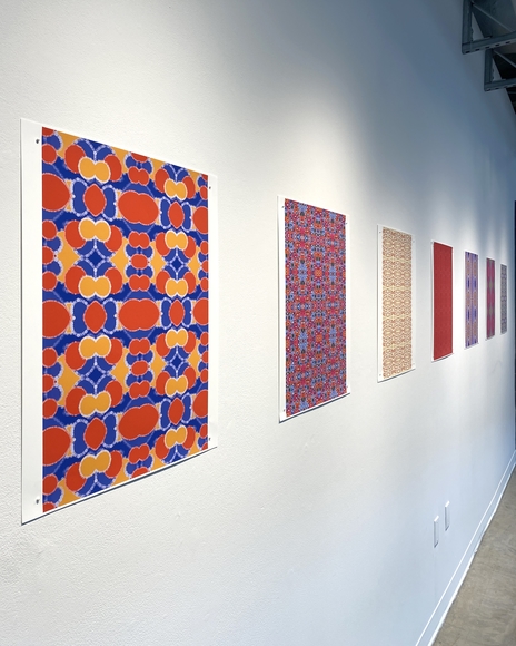Multi-colored prints hanging on a gallery wall