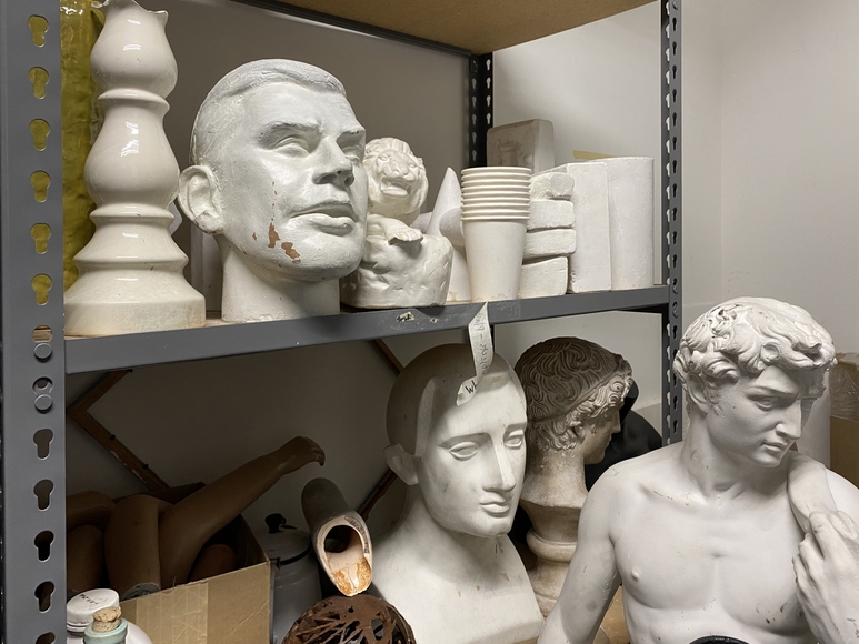 Shelves of fake marble busts and white pottery