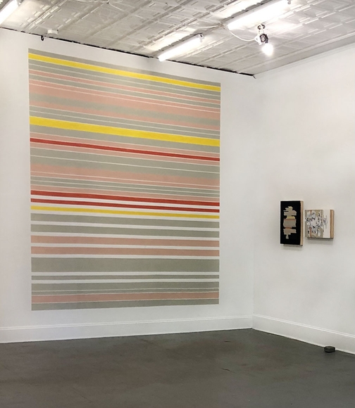 Gallery installation of large horizontally striped mural in yellow, red, white, and gray