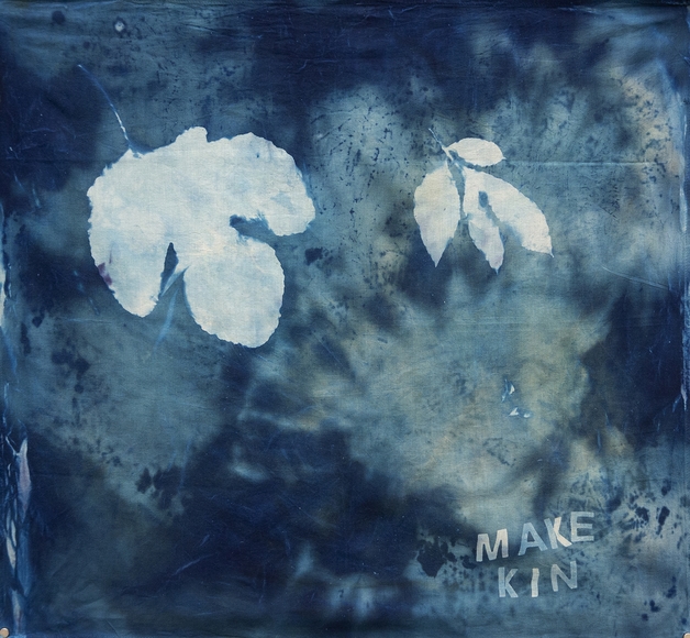 Dark blue tie-dyed square with two leaf silhouettes in white and the words "Make Kin"