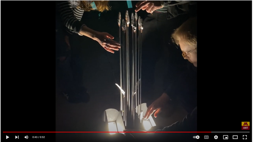 Students "activating" an industrial bouquet made of rods