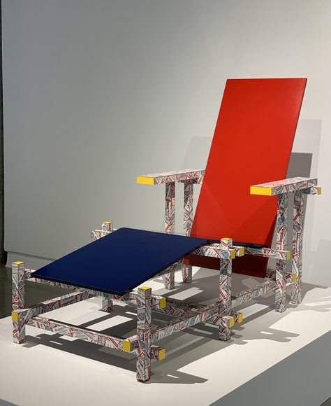 An angular chase lounge with solid red and blue panels and arms and legs covered in Budweiser beer labels.