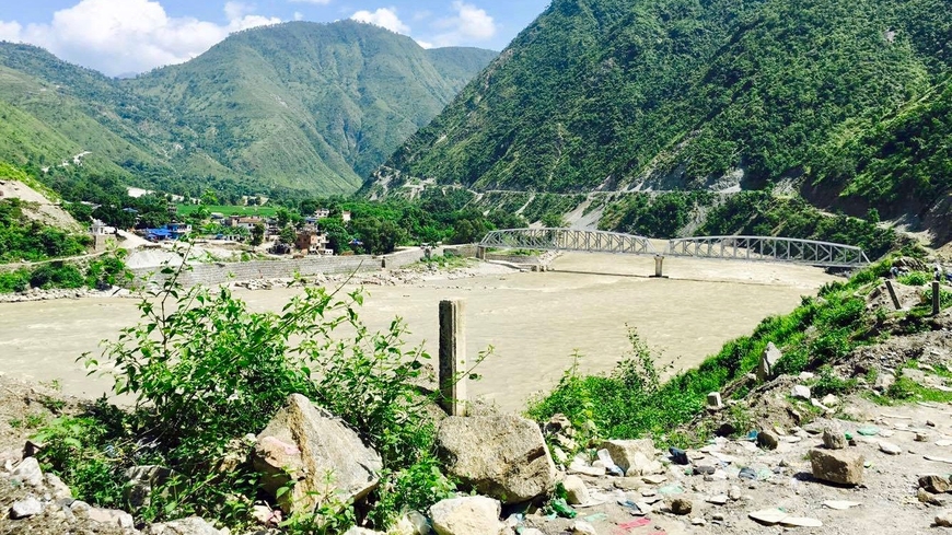 Landscape view of the Koshi River Basin, where the Dendrochronology Center conducted research. Tall mountains and a small town in the background.