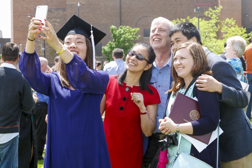 Spring 2015 CLA Commencement - graduate celebrating with friends and family
