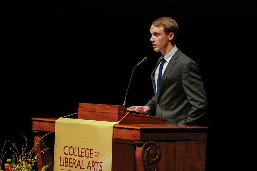 Photo of student Henry Zurn speaking at a podium