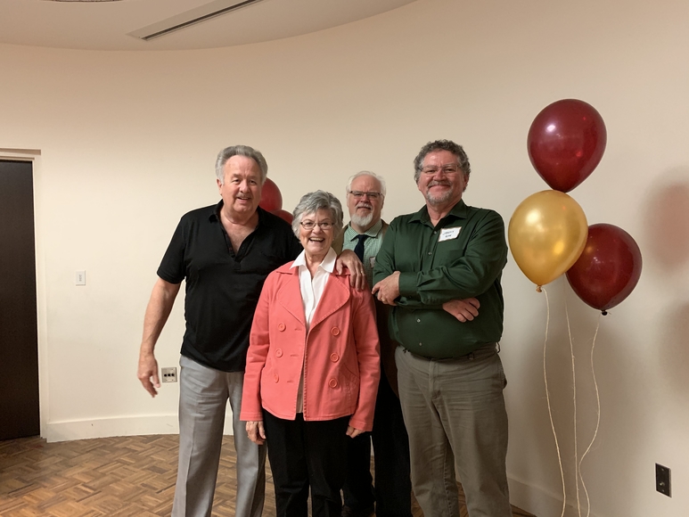 Jerry Behme, Bonnie Behme, Ron Greene, Jeremy Rose stand before maroon and gold balloons