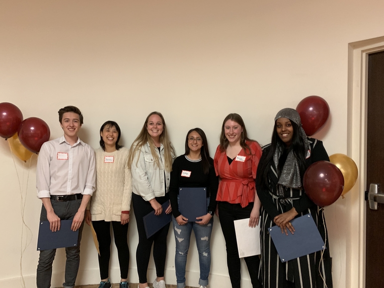 Emilio Vega, Becky Copper, Grace Rogers, Evelyn Aguilar, Hannah Mulholland, Hibo Osman stand in front of maroon and gold balloons