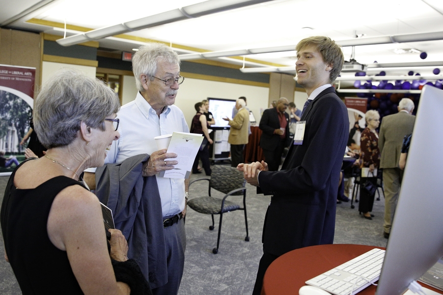 Grad student talking with guests at CLA150 Closing Celebration
