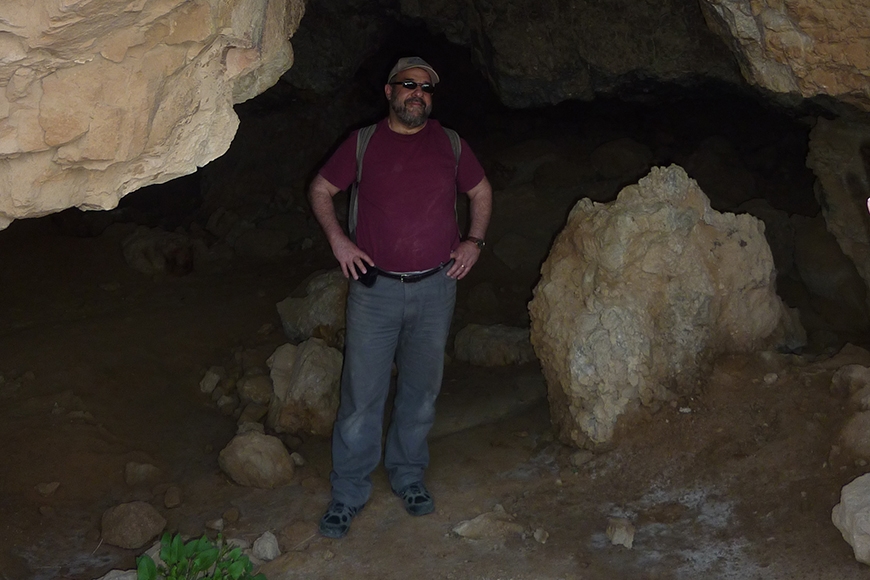 Bernie Levinson stands in the entrance to cave 11.