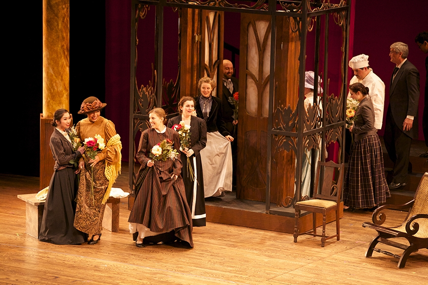 Several people in Victorian dress exiting a door