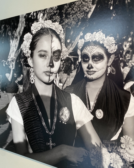 Two young women in Dia de Muertos face paint at a festival.