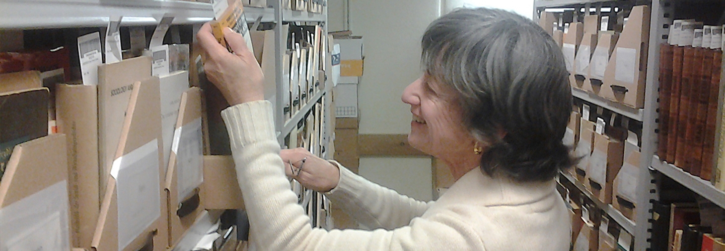 Marilyn Kann McElroy, Robert A. Kann's daughter, examines the Kann Collection.