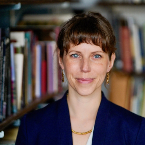 Photo of Anna Lise Seastrand in front of a book shelf.