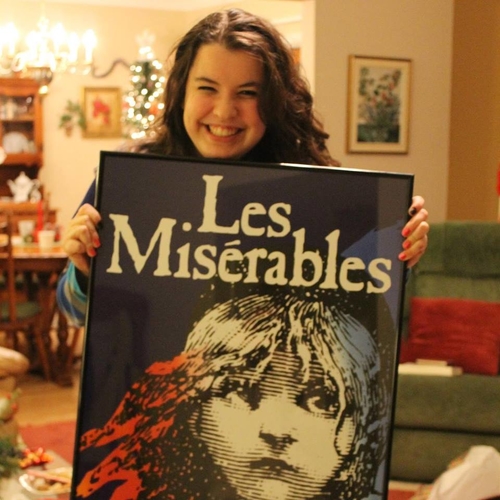Picture of Kathleen Bolander smiling holding a Les Miserables poster