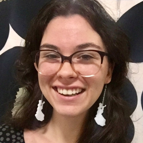 Photo of a smiling woman with Finland shaped earrings