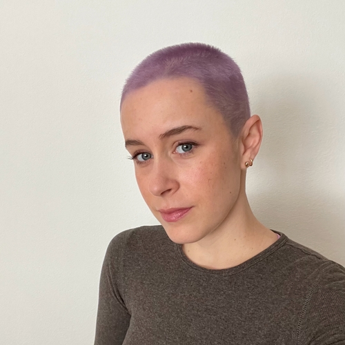 young woman with purple buzz cut hair 
