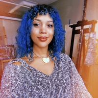 Black woman with blue hair smiling