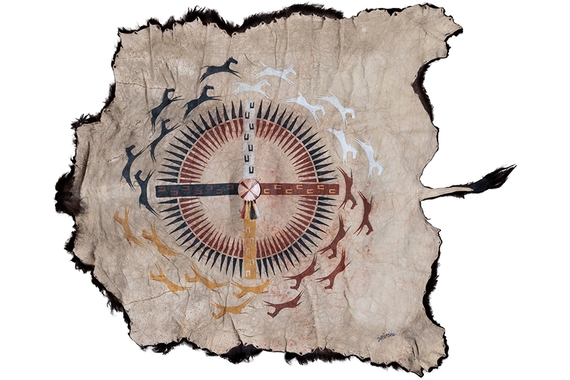 A geometric, compass like design encircled by four different groupings of horses sits at the center of a buffalo hide.