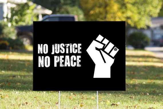 Yard sign with fist graphic reading "no justice no peace."