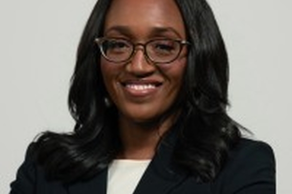 Dr. Lisa Sayles-Adams wearing a black blazer and white shirt, smiling and staring at the camera