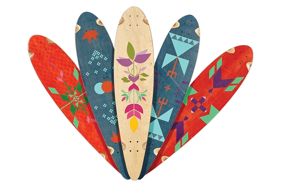 Wall sculpture of five fanned out skateboard decks painted with geometric and floral abstract designs.