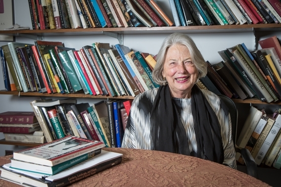 Photo of Cathy smiling in her office in front of book shelves
