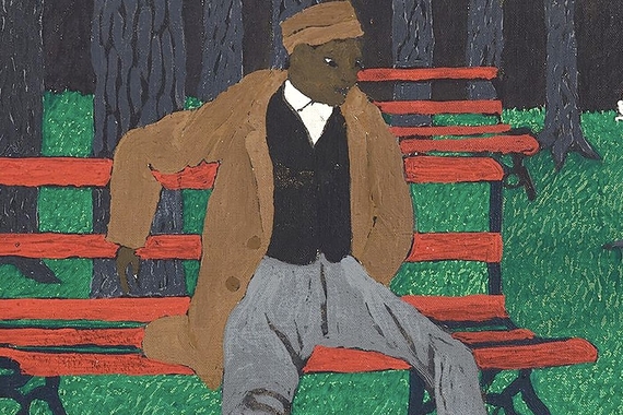 A cropped image of a Black man is seated on a red bench.