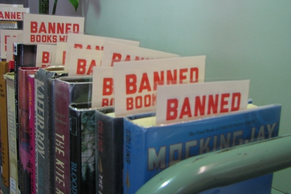 Shelf of library books each with a bookmark sticking out of it that says "Banned Books Week"