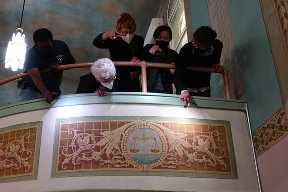 First Church of God in Christ zodiac paintings on interior balcony, with FCOGIC Director John Lewis, Dr. Marilyn Chiat, Jessie Merriam, Jade Ryerson, and Dr. Greg Donofrio looking over the balcony