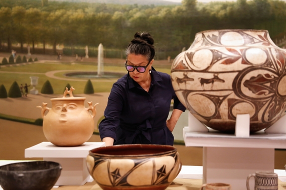 Patricia Marroquin examining a collection of vases