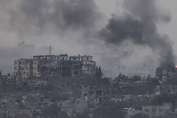 City in Gaza in ruin and on fire from airstrikes.