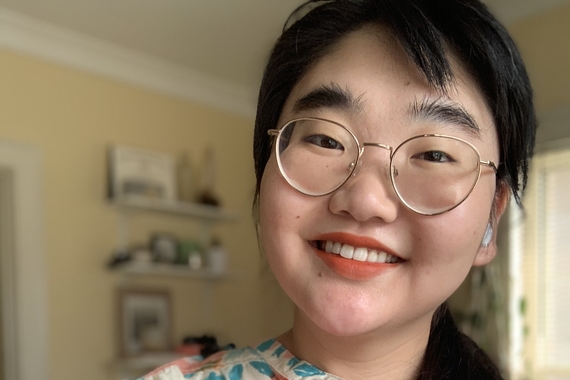 Photo of Ashley E. Kim Duffey smiling and wearing a colorful blouse.