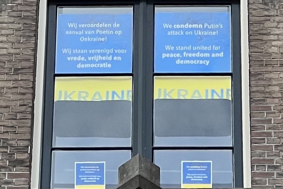 Window in Amsterdam with statement against war in Ukraine in Dutch and English.