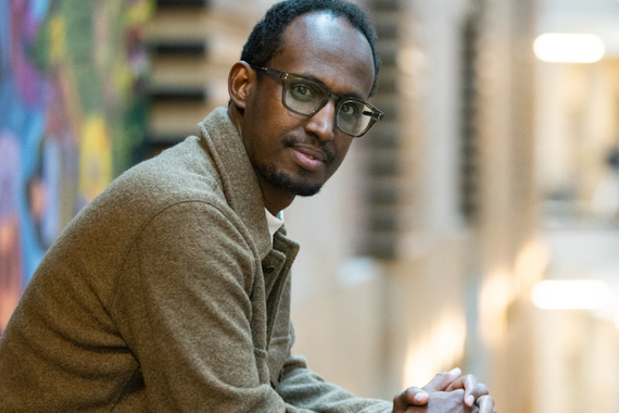 Mukhtar Ibrahim, a person with black hair, mustache and beard, brown skin, and glasses