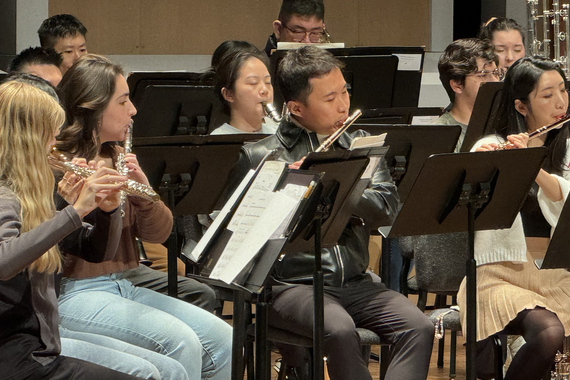 Students in University Wind Ensemble play flute. 