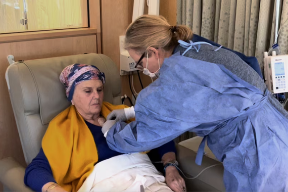 A patient receives a medical infusion from a nurse.