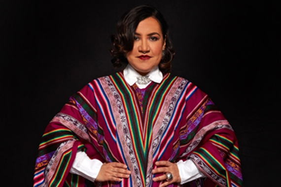 Martha Gomez standing in front of a black background, her hands on her hips