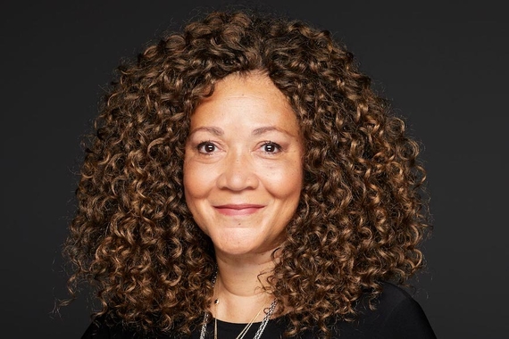 Michele Norris, a person with light brown skin, and shoulder-length hair with ringlets