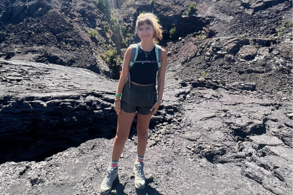 Olivia Berndt stands in the rocky environment of a crater.