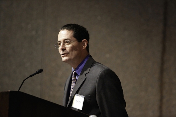 Paul Goren, wearing a suit, speaks at a podium