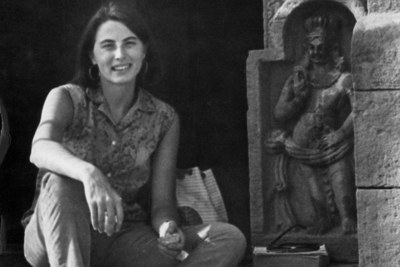 B&W photo of Catherine Asher seated next to Indian art